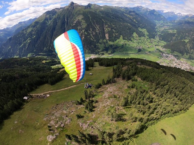 Gleitschirm-Duo schwebt lautlos über das Virgental mit weiter Sicht auf die Hohen Tauern